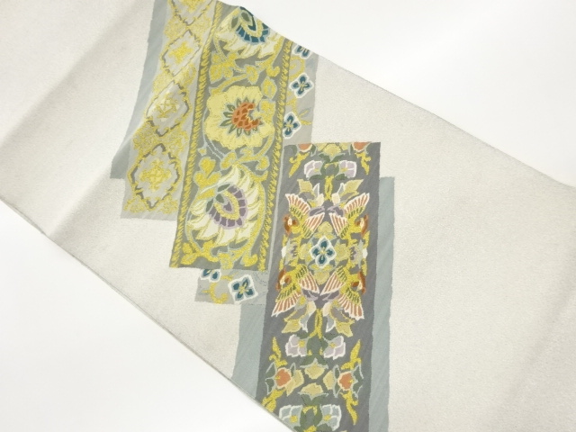 Nagoya obi with woven patterns of birds and flowers facing a tanzaku